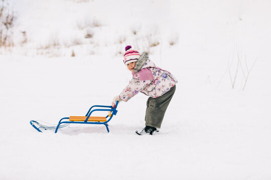 Child enjoying winter sledding fun on holidays