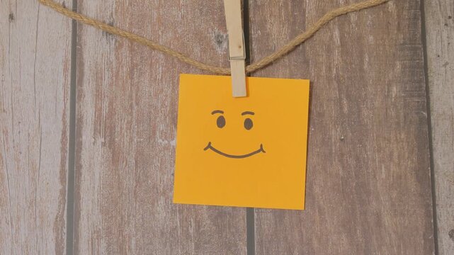 smiley face lying down clothespin orange background