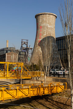 Industrial landscape with cooling tower and yellow bridge