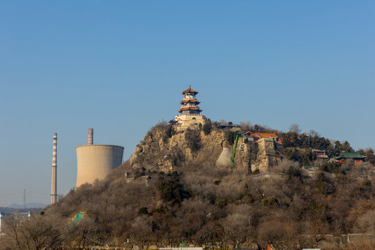 Ancient pagoda overlooking industrial landscape
