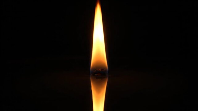 Flame burning on a candle wick.
