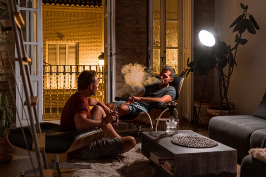 Male friends smoking hookah at home