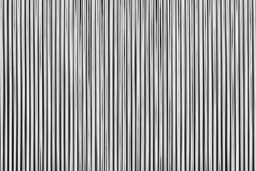 Obraz premium Vertical lines stretch across the frame, bold and stark. Black and white contrast creates a minimalist, graphic feel. The pattern pulses with rhythm, suggesting motion or sound