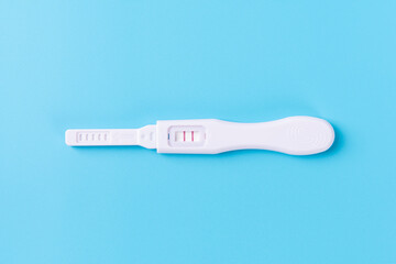 Pregnancy test showing positive result on blue background
