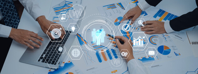 Business professionals engage in collaborative analysis of financial data with charts, graphs, and...