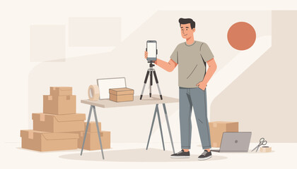 Flat vector illustration of a male small business owner using a smartphone on a tripod to photograph products and packaging boxes in a home office studio for e-commerce shop.