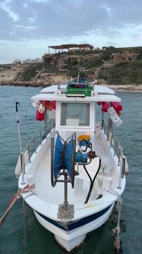 Small white fishing boat with professional net hauler on deck in calm sea