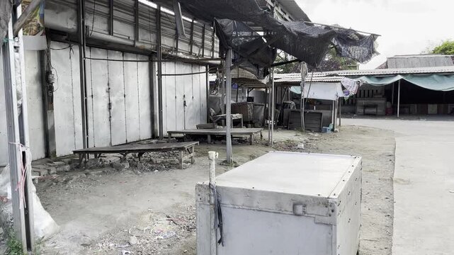 Kios yang tampak terbengkalai dan kotak logam berkarat di lorong perkotaan