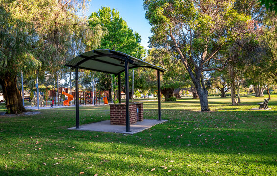 Empty Park Picnic Shelter Near Children's Playground With Trees And Green Grass On Sunny Day in Olives Reserve, Perth, Australia, 25 November 2021