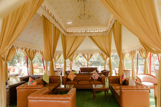 Inviting Elegant Outdoor Event Tent with Luxurious Seating for Relaxation and Social Gatherings under Warm Lighting and Spacious Ambiance