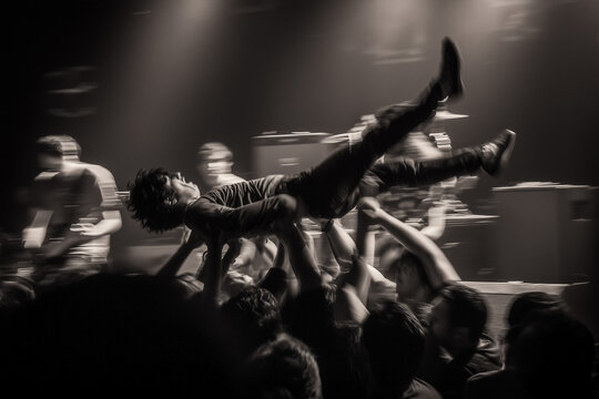 Early 2000s rock concert, crowd surfing fans, stage lights, smoke machines, nu-metal band performance, raw documentary photography