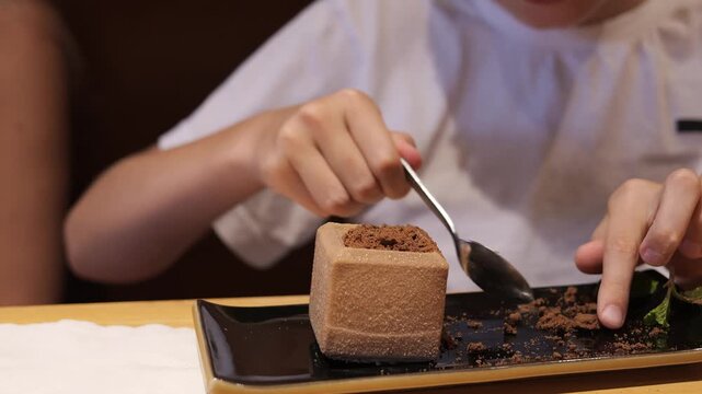 Child tasting gourmet cake at family dinner cake becomes highlight of warm evening Curious kid explores delicate cake texture sharing sweet cake moment in cozy restaurant atmosphere together