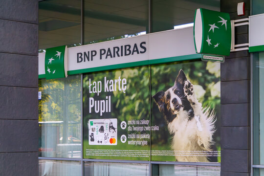 Exterior BNP Paribas bank sign on modern office building, green logo and logotype of financial institution on building facade, glass windows with reflections, professional banking branch signage in ci