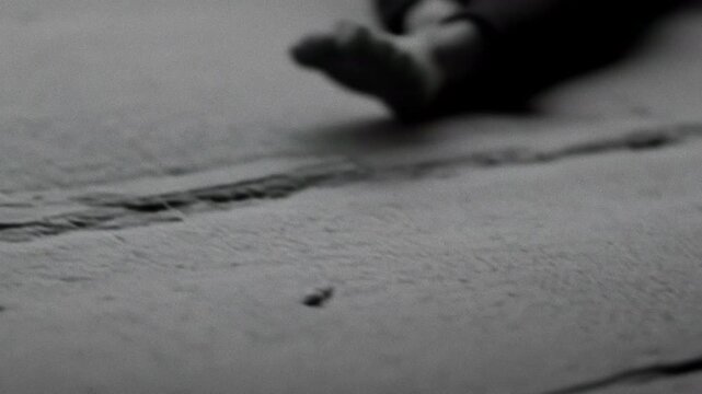 Dancer succumbs quietly. Silent portrayal of dancer collapsing from exhaustion in monochrome. Peaceful black and white depiction of dancer succumbing slowly to weariness