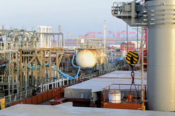 a chemical tanker and bulk carrier are docked at guanjzhou harbor handling hazardous chemicals and...