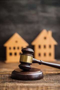 Gavel wooden houses shallow depth backdrop representing property law dispute settlement and legal judgment