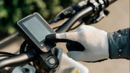 Fototapeta premium Person using electric bike computer display on handlebars
