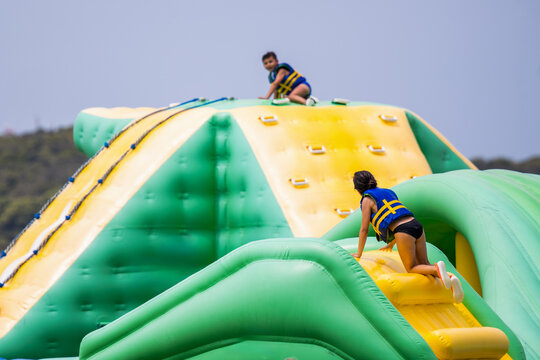 Kids climbing inflatable course at water park