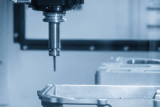 High-precision hole making process on aluminum automotive components using a CNC milling machine in a modern factory.