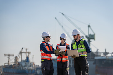 Professional engineering working at shipyard, Professional logistics monitoring cargo operations at industrial shipyard.