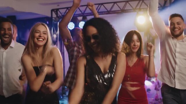 カラフルなパーティーのダンスフロアでエネルギッシュに踊る多様な若者たちのグループ