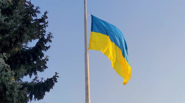 Ukrainian Flag Flies at Half-Mast in Memory of Lost Lives Near City Center in Daylight Hours