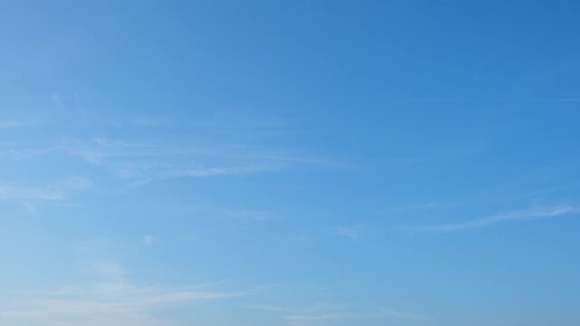 Timelapse footage of a vivid blue sky with fluffy cumulus cloud formations evolving gradually, highlighting natural cloud development, sunlight diffusion, and calm atmospheric motion.
