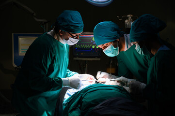 Group of concentrated surgical doctor team doing surgery patients in hospital operating theater. Professional medical team doing critical operations.