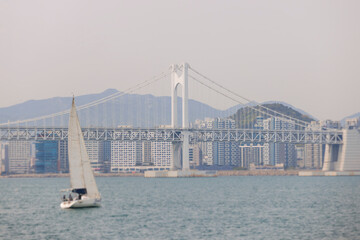 Obraz premium Busan Bay yacht boat cruise, Busan, South Korea, Yongho-dong, with Gwangan Diamond bridge, marina skyline and port harbor panorama, during boat excursion tour, Korean Strait, Haeundae river cruise