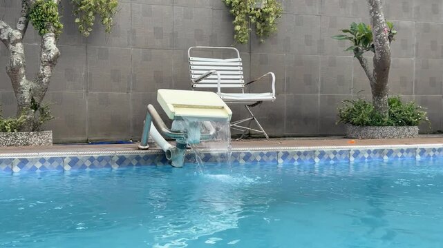 Swimming pool filtration system circulating clear blue water.