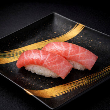 Premium fresh medium fatty tuna chutoro sushi on a luxury black ceramic plate with gold brushstrokes, dramatic lighting, high-end traditional Japanese cuisine.