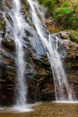 Fototapeta premium Waterfall within the forest with rocks covered in moss in Minas Gerais