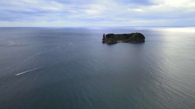 Cinematic aerial drone view of the volcanic islet of Vila Franca do Campo near S&atilde;o Miguel Island in the Azores, Portugal. The ring-shaped crater forms a natural lagoon surrounded by dramatic cliffs an