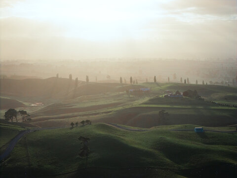 Drone aerial at sunrise over rolling hills of Hobbiton in New Zealand