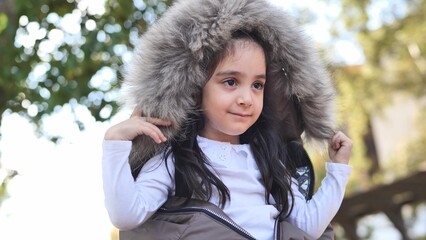 Young girl smiling and having fun outdoors, dressed in warm winter clothing