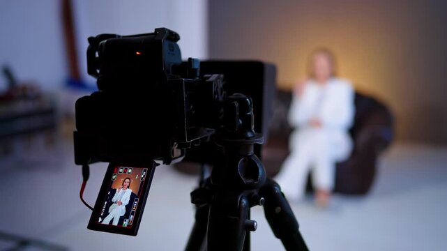 Display of modern camera showing a lady in white suit. Close up. Footage of the blog content in studio.