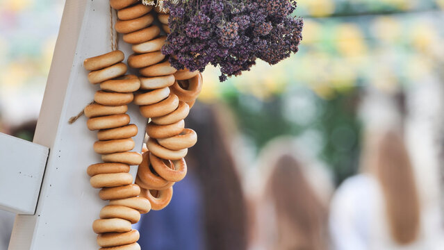 Traditional Russian sushki bagels hanging at an outdoor market stall, food tradition