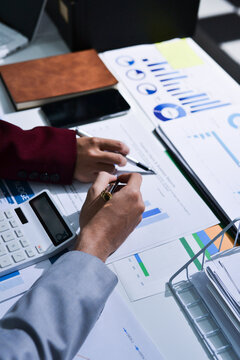 Business people analyzing monthly budget and financial report using data and chart to strategize and plan for their future business while working together in the office.