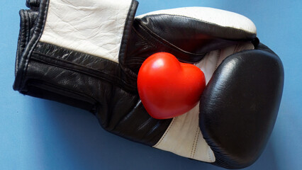 Boxing glove holding red heart symbolizing health fighting
