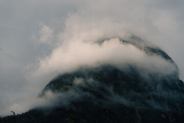 Fototapeta premium Sunrise through mountain range of Milford sound showing mountain peaks on a boat