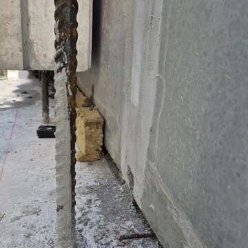 Close-up of a precast concrete element being lowered and precisely positioned on a construction site.