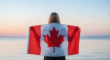 Canada day celebration with patriotic woman wearing maple leaf flag on beach at sunset