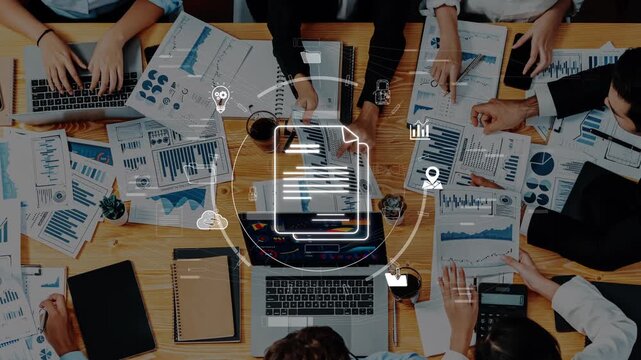 A diverse team engages in a collaborative session surrounded by digital devices and printed reports to analyze data and create effective strategies. Raster