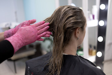 Naklejka premium Close-up of applying a hair mask to hair in a salon