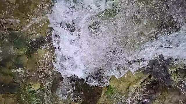 Die Wellen und Str&ouml;mung von einem kristallklaren Gebirgsbach in extremer Zeitlupe und im Detail der Wasseroberfl&auml;che