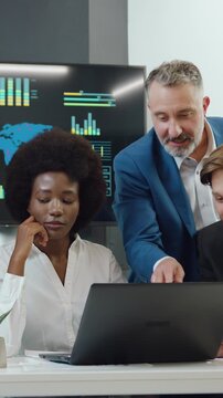 Good-looking friendly positive confident enterprising diverse corporate coworkers advising as to the business strategy using reports with charts and datas from laptop during meeting in boardroom