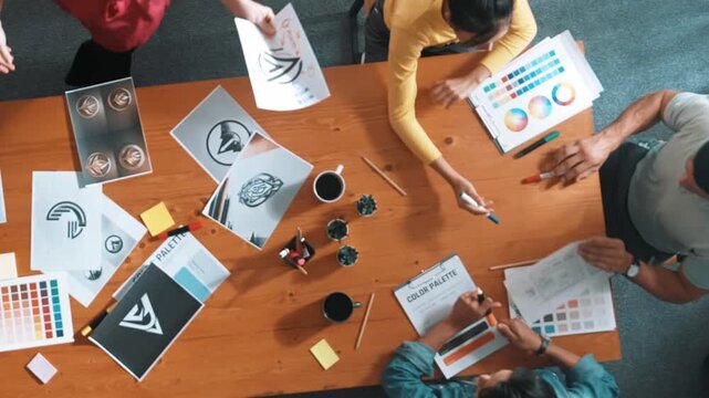 Top view of manager writing idea on sticky notes and explain idea about web design. Professional marketing team or programmer brainstorming idea while looking at tablet with color palette. Symposium.