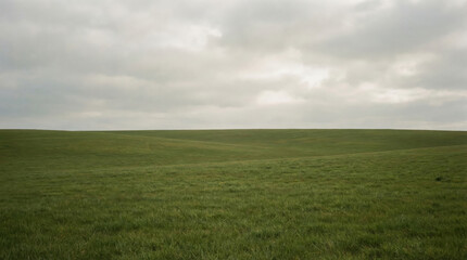 Obraz premium Vast Green Rolling Hills Under an Overcast Cloudy Sky