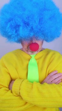 Unhappy and serious man in a clown costume with crossed arms isolated on a white background