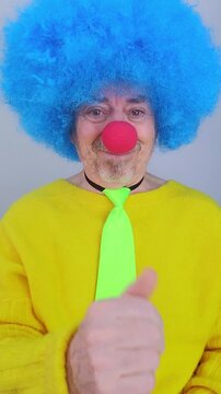 Smiling clown making the come here hand gesture isolated on a white background